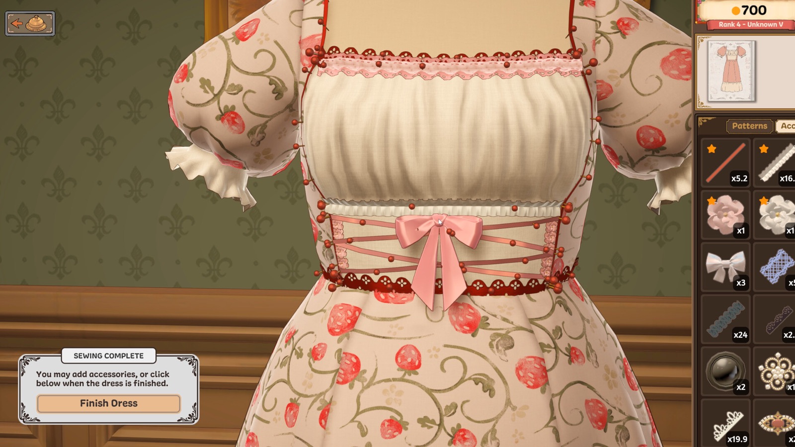 Official Dressmaker gameplay screenshot showing a finished strawberry-print dress, sewing pins, accessory inventory, and completion UI